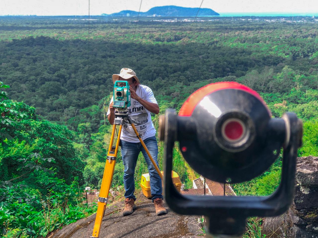 Imagem de um homem realizando o procedimento de levantamento topográfico